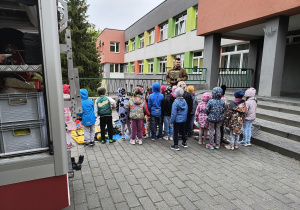 Dzieci oglądają ekwipunek strażacki.