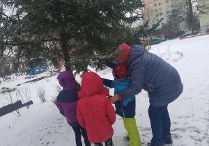 Dzieci dokarmiają ptaki.
