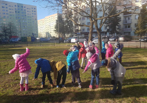 Dzieci uczestniczą w zabawach ruchowych w ogrodzie.