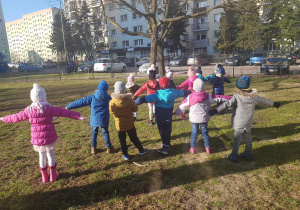 Dzieci uczestniczą w zabawach ruchowych w ogrodzie.