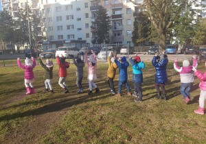 Dzieci uczestniczą w zabawach ruchowych w ogrodzie.