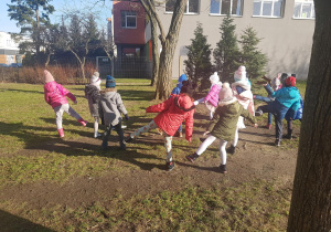 Dzieci uczestniczą w zabawach ruchowych w ogrodzie.
