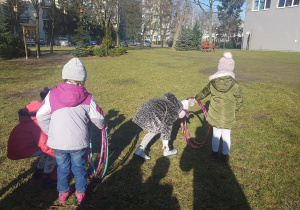 Dzieci uczestniczą w zabawach ruchowych w ogrodzie.