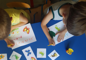 Dzieci przygotowują tabliczki na temat ochrony przyrody.