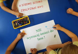Dzieci przygotowują plakaty na temat ochrony przyrody.