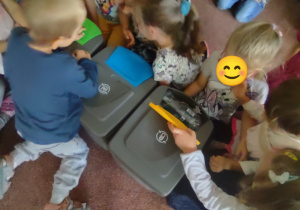 Dzieci uczestniczą w zajęciu edukacyjnym na temat segregacji odpadów.