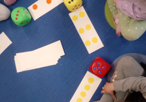 Dzieci bawią się kostkami matematycznymi.