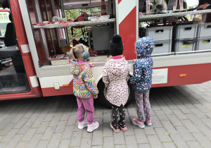Dzieci oglądają wóz strażacki.