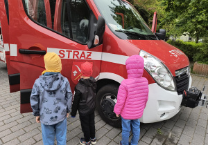 Dzieci oglądają wóz strażacki.