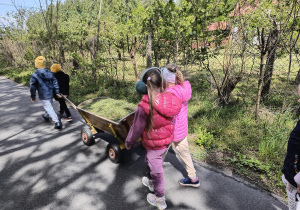 Dzieci ciagną wózek z sianem.