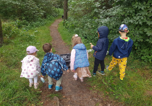 Grupa dzieci idzie ścieżką w parku.
