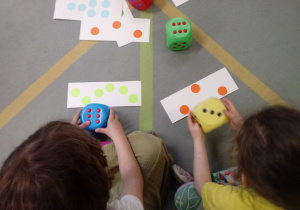 Dzieci bawią się kostkami matematycznymi.
