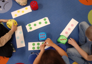 Dzieci bawią się kostkami matematycznymi.